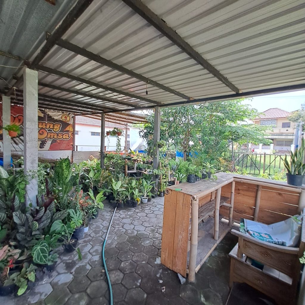 Dari Foto ini, tanpa merubah bentuk, tanpa merubah angle foto, tanpa merubah posisi rumah, tanpa merubah dimensi, tanpa merubah dan mengurangi detail rumah. Tanpa merubah jalan depan rumah. Buat foto ini menjadi lebih detail, lebih realistis, dan lebih jernih 8K. Tambahkan brightness dan Contrast yang seimbang pada foto bagian depan rumah. Tambahkan pencahayaan cinematic dari berbagai sisi. Kurangi shadow pada detail rumah sehingga lebih terlihat jelas. Hilangkan mobil, hilangkan sepeda moto, dah hilangkan sampah pada depan rumah. Hilangkan Spanduk. Jangan rubah jalan depan rumah. Buat langit menjadi biru cerah dan sedikit awan. Buat kondisi menjadi siang hari yang cerah. Rubah ukuran dimensi foto menjadi portrait 4:5. Komposisikan menambah luas langit nya. Zoom out foto ini agar rumah menjadi lebih kecil, dan sudut pandang menjadi lebih jelas. Jangan rubah bentuk jalan depan rumah. Terangkan bagian depan rumah yang masih gelap.